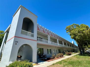 Exterior of condo featuring a well-maintained building, landscape and open balcony at 2100 World Parkway Blvd # 50, Clearwater, FL 33763
