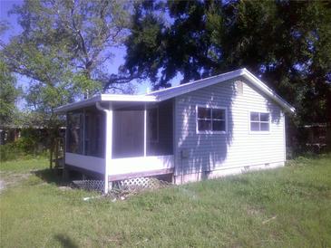 Quaint single-story home with a screened porch nestled among mature trees in a spacious yard at 710 E 129Th Ave, Tampa, FL 33612