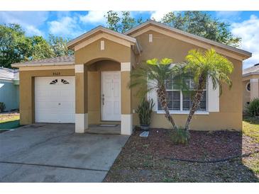 Charming single-story home with tan stucco, an arched doorway, and neat landscaping in a sunny setting at 8528 Quarter Horse Dr, Riverview, FL 33578