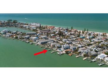 Stunning coastal home on stilts with a private dock and boats along a tranquil waterfront at 8685 E Bay Dr, Treasure Island, FL 33706