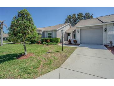Charming single-story home with manicured lawn, mature landscaping, and a two-car garage at 18836 Summersong Dr, Hudson, FL 34667