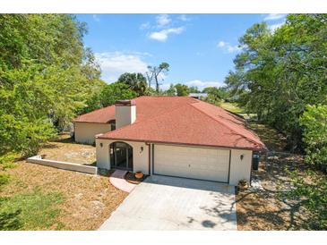 Charming home featuring a well-maintained lawn, two-car garage and a welcoming front entrance at 5140 Kirkwood Ave, Spring Hill, FL 34608