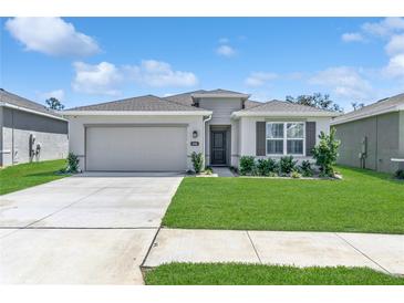 Charming single-story home featuring a well-manicured lawn, two-car garage, and stone-accented facade at 8352 Greenway Ave, Wesley Chapel, FL 33544