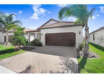 Charming single-story home featuring a tile roof, a two-car garage, and beautifully maintained landscaping at 17214 Star Banks St, Wimauma, FL 33598