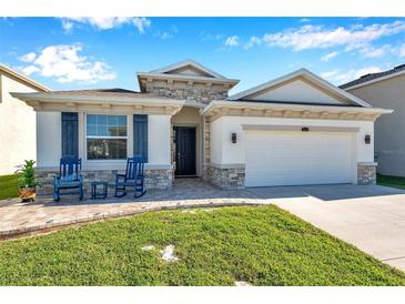 Charming single-Gathering home with stone accents, two-car garage and inviting front porch at 2934 Living Coral Dr, Odessa, FL 33556