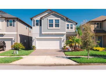 Charming two-story home with a brick driveway, two-car garage, and well-maintained landscaping at 8609 Winning Fields Rd, New Port Richey, FL 34655