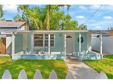 Charming home featuring a quaint front porch, seating area, and fresh exterior paint at 4803 N 9Th St, Tampa, FL 33603