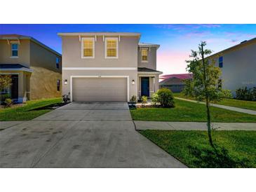 Two-story home with a two-car garage, landscaping, and a concrete driveway at 5758 Hollingworth Trl, Wesley Chapel, FL 33545