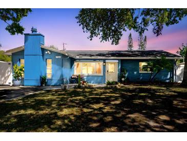 Charming blue single-story home featuring a well-manicured lawn and mature trees at dusk at 7901 42Nd N St, Pinellas Park, FL 33781