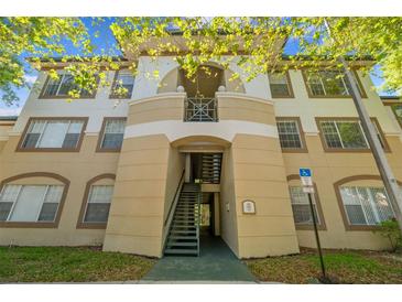 Exterior view of a beige two-story apartment building with stairs leading up to the units at 17108 Carrington Park Dr # 711, Tampa, FL 33647