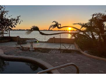 Waterfront view from a home, showcasing the serene sunset reflecting on the water and nearby cityscape at 1844 Venetian Point Dr, Clearwater, FL 33755