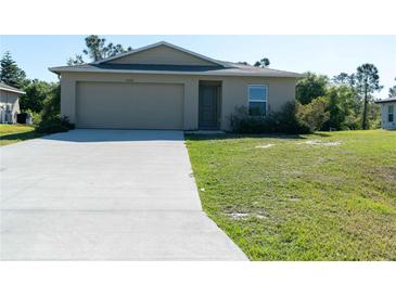 Single-story home featuring an attached garage, a simple lawn, and neutral-toned exterior at 6422 Towhlen Rd, North Port, FL 34291