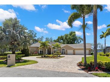 Beautiful single-story home with a circular brick driveway and lush tropical landscaping at 10905 Elliot St, Riverview, FL 33578