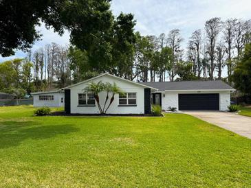 Charming single-story home featuring a well-manicured lawn and dark accents at 210 Lake Hobbs Rd, Lutz, FL 33548