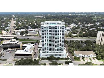 Stunning aerial view of modern high-rise condo building with pool, overlooking the city and a lush tree canopy at 2910 W Barcelona St # 403, Tampa, FL 33629