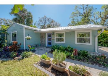 Charming single-story home featuring a well-manicured lawn and a whimsical blue front door at 604 W Hilda St, Tampa, FL 33603