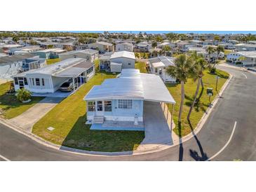 Charming blue single-story home with covered parking and well-maintained landscaping in a quiet community at 128 E Saint Johns Way, Apollo Beach, FL 33572