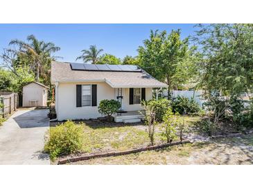 Charming home featuring a well-kept lawn, neutral paint, shutters and solar panels for energy efficiency at 2414 W State St, Tampa, FL 33609