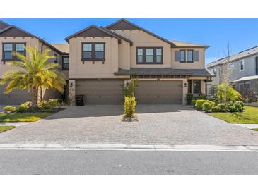 Beautiful two-story home with a two-car garage and a paver driveway and lush landscaping at 4600 Lagona Ln, Wesley Chapel, FL 33543