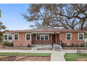Charming brick home with a metal roof, landscaped yard and mature trees at 5010 45Th N Ave, St Petersburg, FL 33709