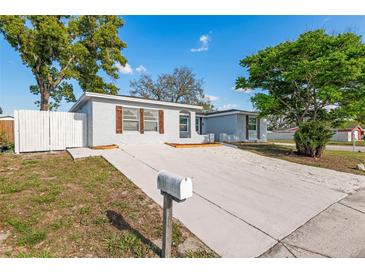 Charming single-story home with a well-manicured lawn and a long, private driveway at 9216 Mark Twain Ln, Port Richey, FL 34668