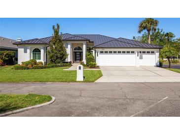 Stunning single-story home features a three-car garage, manicured lawn, and contemporary architectural details at 1002 Romano Ne Ct, St Petersburg, FL 33702