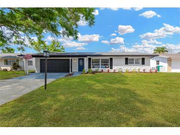 Charming single-story home with a well-manicured lawn and a driveway leading to a two-car garage at 11361 88Th Ave, Seminole, FL 33772