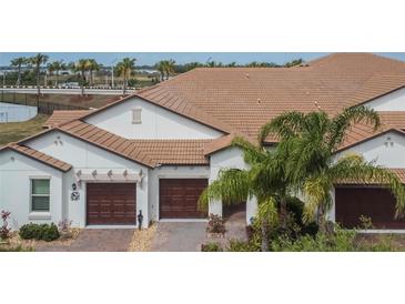 A beautiful exterior view of a well-maintained home with a tile roof and three-car garage at 16927 April Plush Dr, Wimauma, FL 33598