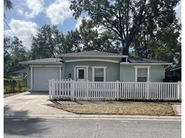 Charming single-story home featuring a well-maintained lawn and a classic white picket fence at 3211 E 23Rd Ave, Tampa, FL 33605