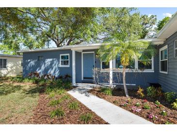 Charming home featuring a blue exterior, complemented by lush landscaping and a well-manicured front yard at 4105 W Fair Oaks Ave, Tampa, FL 33611