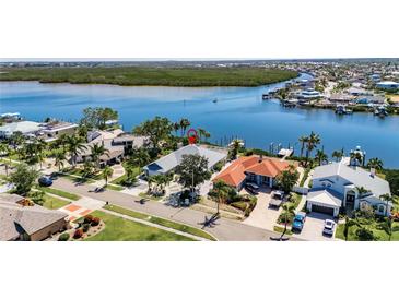 Waterfront home with boat dock and pool, offering stunning aerial views and lush surroundings at 6603 Seabird Way, Apollo Beach, FL 33572