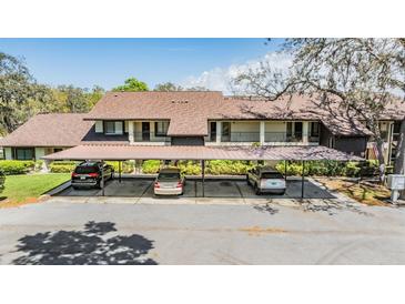 Two-story home with a covered carport and well-maintained landscaping with mature trees and shrubs, providing ample shade at 3610 Magnolia Ridge Cir # 1322/H, Palm Harbor, FL 34684