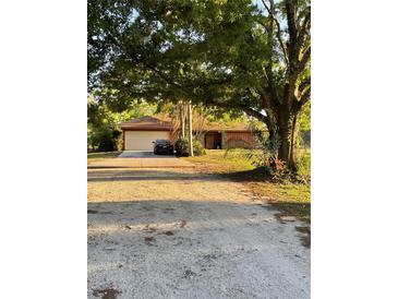 Charming single-story home with a large front yard and attached two-car garage offering a cozy and inviting curb appeal at 7006 41St E Ave, Bradenton, FL 34208