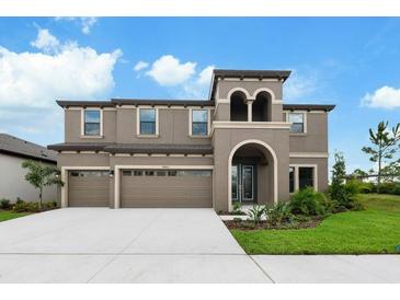 Stunning two-story home features a three-car garage and well-manicured lawn at 14403 Woodland Spur Dr, Lithia, FL 33547