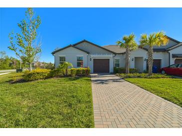Charming single-story home with a well-manicured lawn, paver driveway, and mature landscaping at 16710 Shell Bay Dr, Land O Lakes, FL 34638