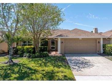 Charming single-story home with a well-manicured lawn, mature trees, and a two-car garage at 2312 Heron Cir, Clearwater, FL 33762