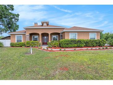 Beautiful single-story home featuring a well-manicured lawn and stucco exterior with stone column accents at 260 Moccasin Hollow Rd, Lithia, FL 33547