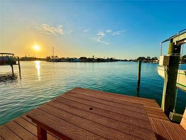 Waterfront dock featuring a seating area and beautiful views of the surrounding water and sunset at 540 115Th Ave, Treasure Island, FL 33706