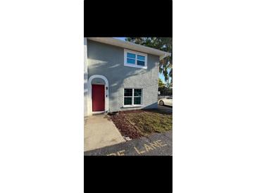 Charming two-story home features a red front door, well-maintained lawn, and clean architectural lines at 5715 Townhouse Dr # 1, New Port Richey, FL 34652