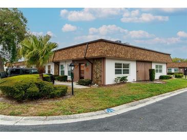 Charming single-story home with a palm tree, landscaped yard, and stylish stone accents on the facade at 6188 Chesham Dr # 5, New Port Richey, FL 34653