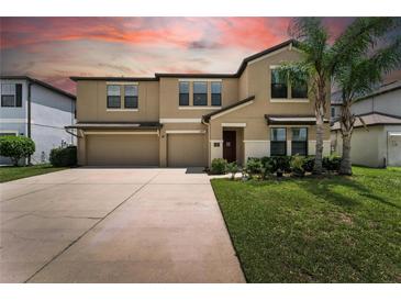 Charming two-story home featuring a two-car garage, landscaped yard, and welcoming front entrance at 14050 Arbor Pines Dr, Riverview, FL 33579
