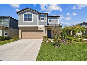 Charming two-story home with a well-manicured lawn and attached two-car garage at 22287 Storybook Cabin Way, Land O Lakes, FL 34637