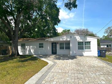Charming one-story home with brick-paved driveway and lush green lawn at 2315 Carroll Pl, Tampa, FL 33612