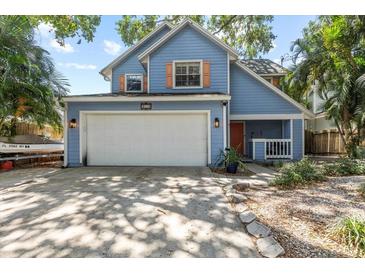 Charming blue two-story home featuring a wide driveway and attached two-car garage at 3710 W Tacon St, Tampa, FL 33629