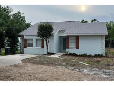 Charming single-story home with a light blue exterior, wooden shutters, and manicured landscaping at 10408 N 50Th St # 1/2, Tampa, FL 33617