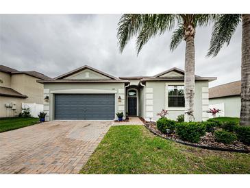Charming single Gathering home with a well-manicured lawn, palm trees, and a brick paved driveway at 1155 Lawnview Ter, New Port Richey, FL 34655