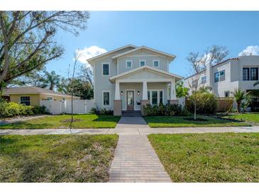 Charming two-story home with a manicured lawn and inviting brick walkway on a sunny day at 1550 48Th N Ave, St Petersburg, FL 33703