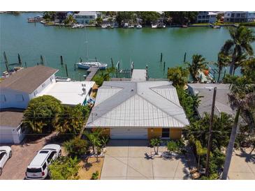 Waterfront home with boat dock and lift, lush landscaping, and a large driveway for multiple cars at 14043 E Parsley Dr, Madeira Beach, FL 33708