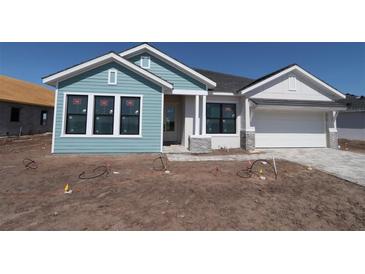 New construction single-story home featuring Hardie siding, stone accents, and a two-car garage at 18051 Foxtail Loop, Venice, FL 34293