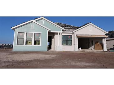 Charming single-story home with a two-car garage, and a mix of light blue and cream exterior paint at 18051 Foxtail Loop, Venice, FL 34293